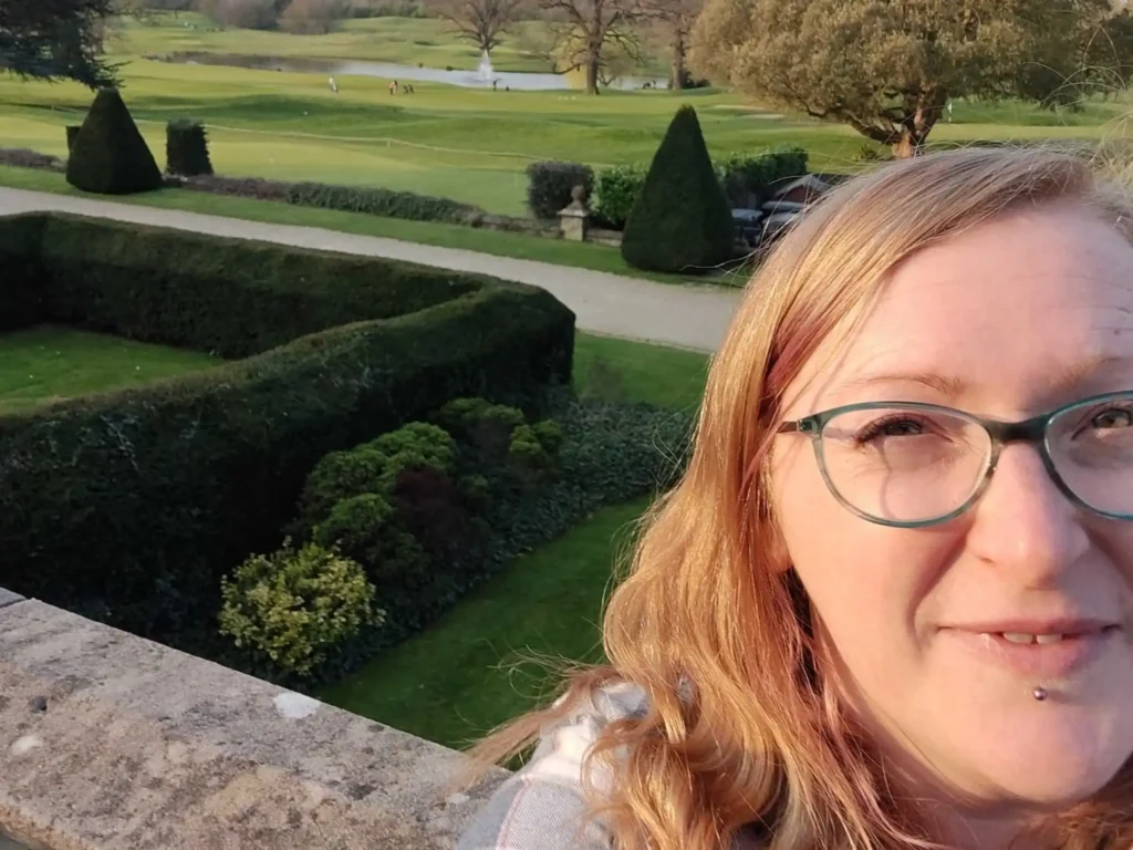 lady with glasses taking selfie in posh garden