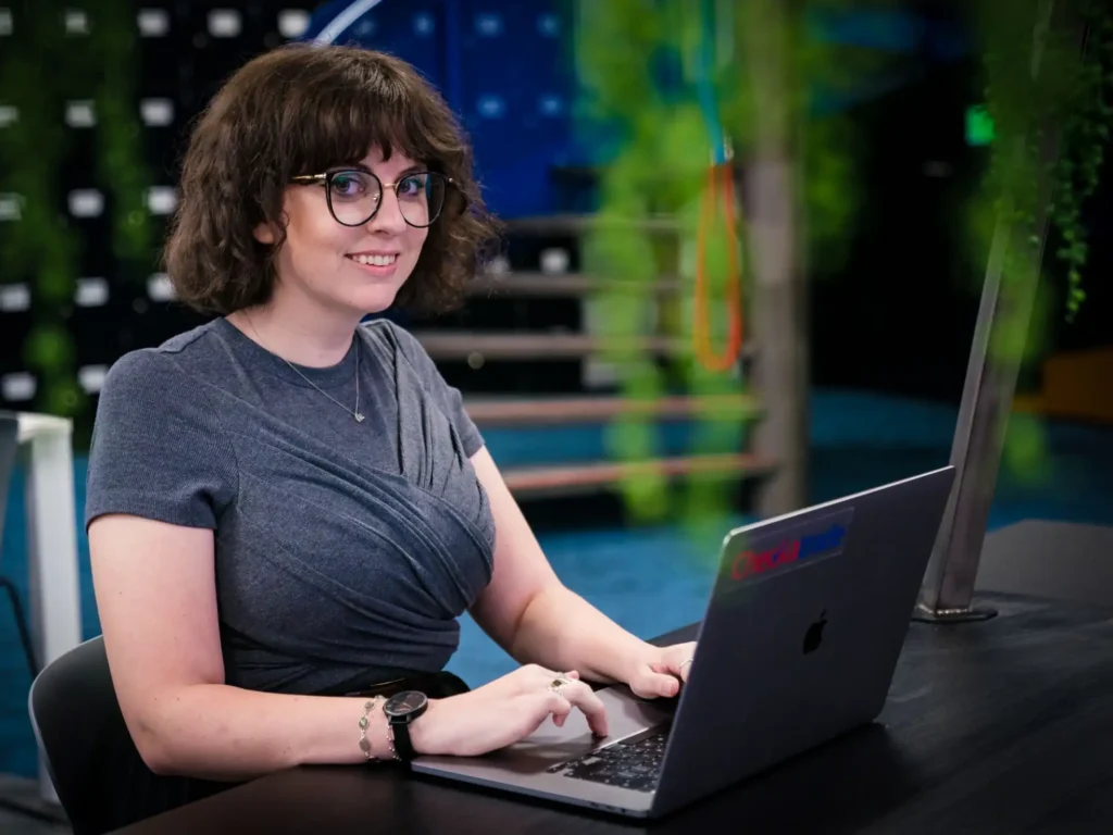 person working on laptop wearing glasses and grey top