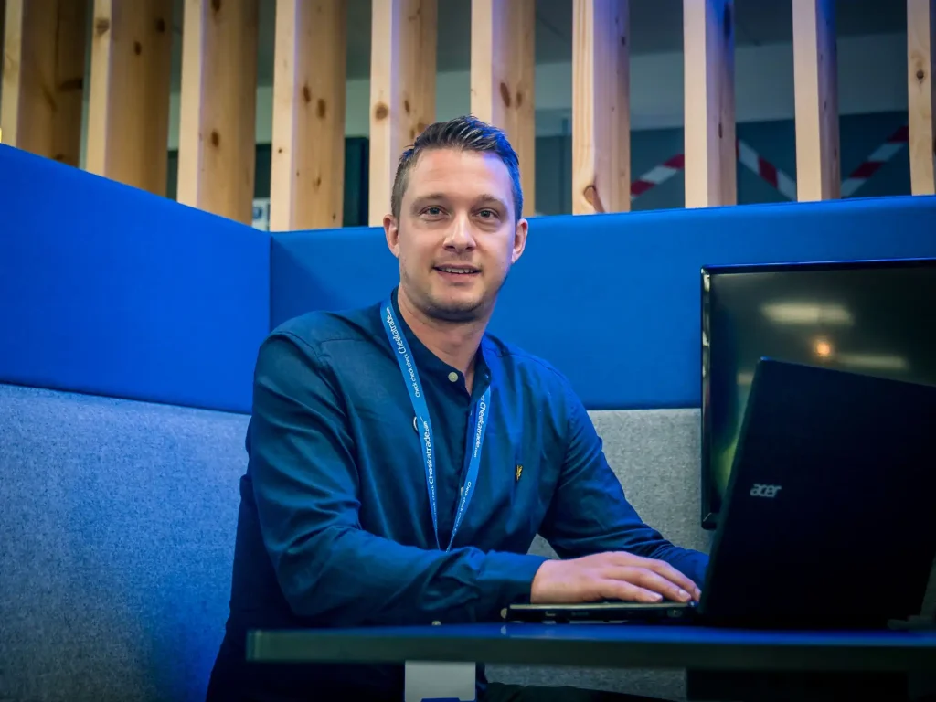 man in blue suite working at car laptop in blue booth