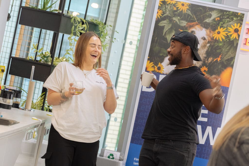 2 co-workers laughing in the workplace