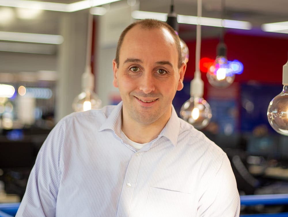 man in blue shirt, lightbulbs in background